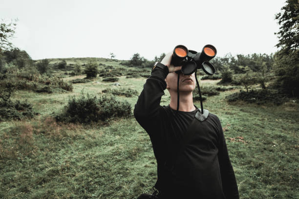istock Hiker looking through binoculars in front of hills and mountain range. Prevalla, Prizren, Kosovo 1128991608