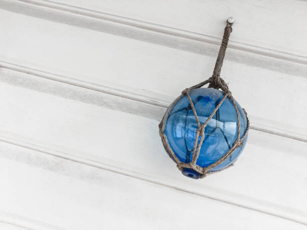 istock Blue glass ball decorating a white wooden wall 1128991762