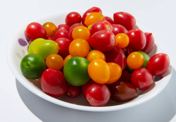 istock Large quantities of colored tomatoes on a plate against a white background 1128992580