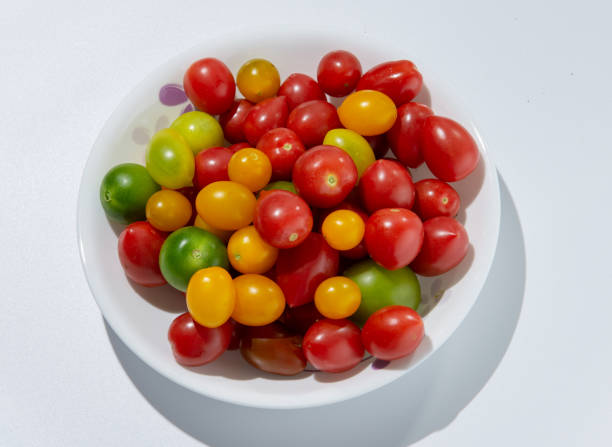 istock Large quantities of colored tomatoes on a plate against a white background 1128992725