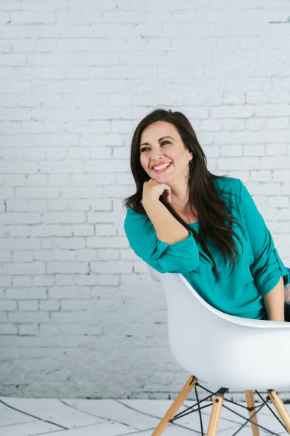 istock Beautiful Woman Against a White Brick Wall 1128995721