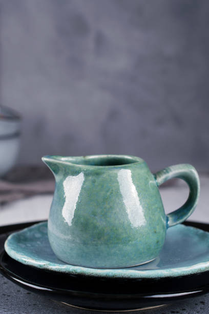 istock Country, rustic style handcraft kitchenware. Blue ceramic cream jug on grey background 1128996956