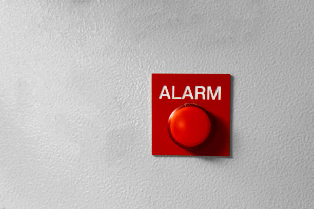 segnale del pulsante allarme rosso sulla parete grigia dipinta. concetto di qualsiasi situazione di allarme - incendio, bancarotta, rapina, ecc. - fire button foto e immagini stock