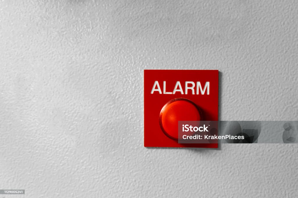 Red Alarm button signal on the painted grey wall. Concept of any alarm situation - fire, bankrupt, robbery etc Red Alarm button signal on the painted grey wall. Concept of any alarm situation - fire, bankrupt, robbery etc. Push Button Stock Photo