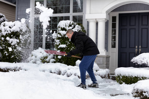 istock Mature man removing snow in front of home 1129005599