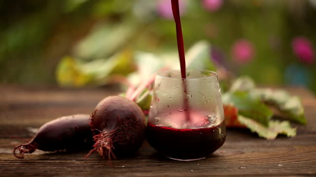 beet  juice in glass on wooden table