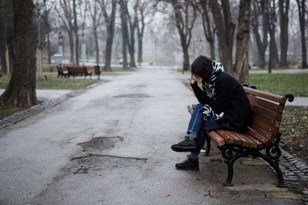 istock Sad girl on a bench 1129008418