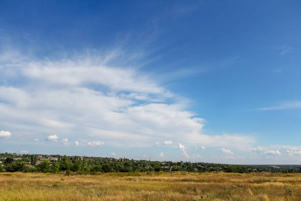 istock Clouds on a bright blue sky. Colorful landscape, field, sunny weather. Selective focus, place for text. 1129011683