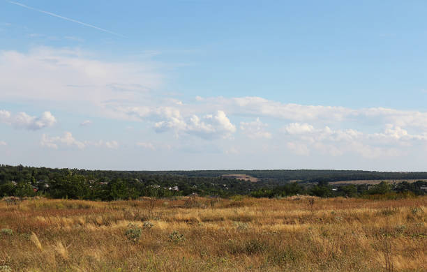 istock Clouds on a bright blue sky. Colorful landscape, field, sunny weather. Selective focus, place for text. 1129011687