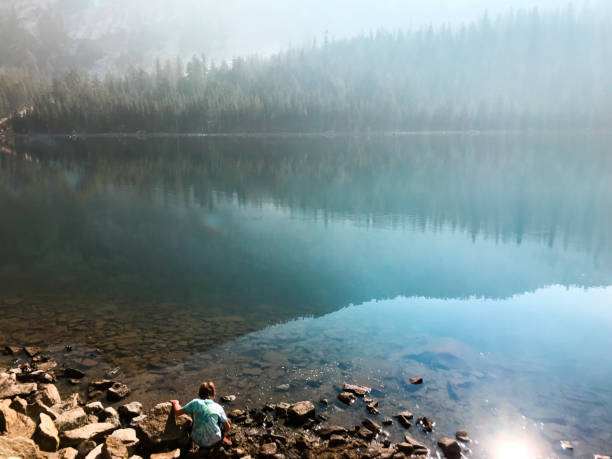 istock Children play by a lake with a beautiful reflection in the mountains 1129019949