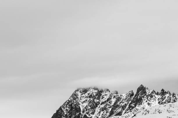istock Rocky mountains in snow and overcast gray sky 1129019958