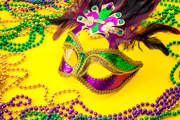 istock Fat Tuesday traditional accessory and Mardi Gras carnival concept theme with close up on a face mask full of color, feathers and texture and colorful beads, a staple of the festival in New Orleans 1129020199