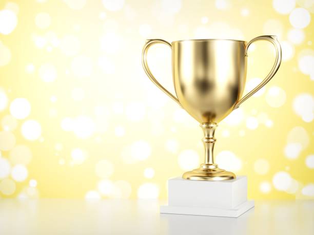 istock Gold trophy isolated on yellow background. 1129022862