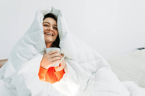 istock Young woman having coffee under the duvet 1129024550