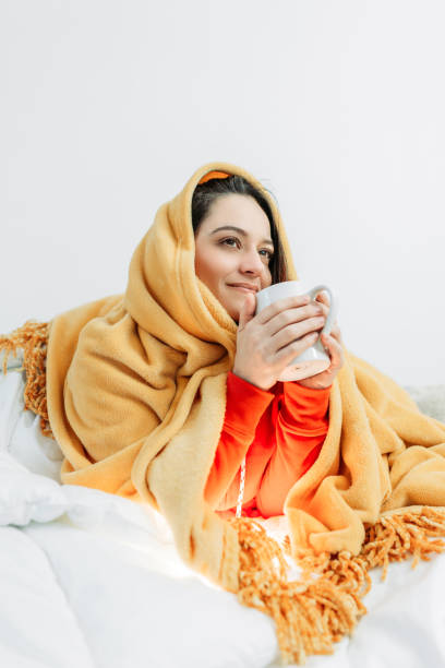 istock Young woman having coffee under the duvet 1129024657