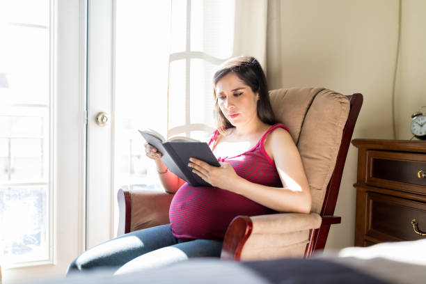 istock Expectant Mother Reading Stories For Unborn Baby 1129025486