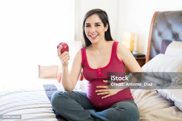 Expectant Woman Enjoy Snacking On An Apple Stock Photo - Download Image Now - Eating, Mexico, Pregnant