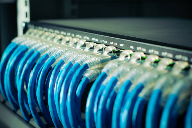 rj45 Connector or UTP cat6 cable connected on network switch in data server room. close up and blur background. stock photo
