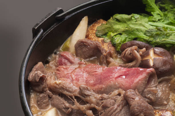 Sukiyaki Sukiyaki is one of the most famous Japanese dishes. Sukiyaki is the name, people will know most. Boil the beef and vegetables with sugar and soy sauce and eat it with eggs twisted. crown daisy stock pictures, royalty-free photos & images