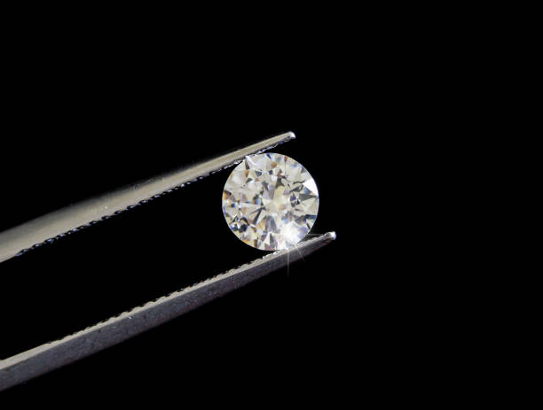 istock Diamond round shape in tweezers. 1129031068