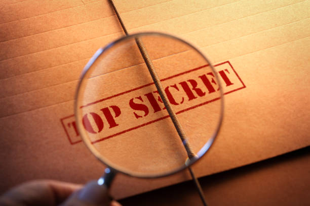istock Looking Through Magnifying Glass At Top Secret File 1129032667