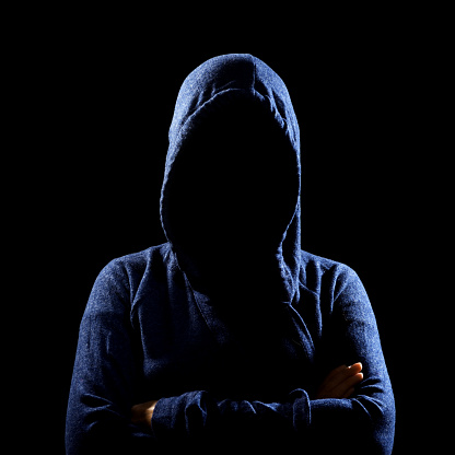 Silhouette of unrecognizable woman in hoodie on black. anonymous or criminal concept