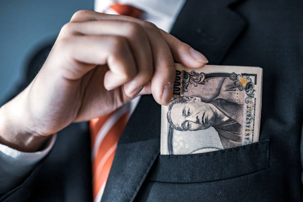 istock businessman holding Japanese yen bill 1129044469