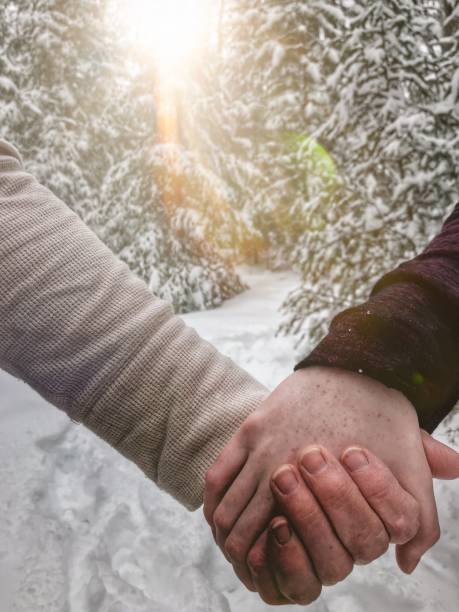 deux mains féminines, grand-mère et petit-fils tenant serré tandis que sur une aventure de randonnée dans les bois blancs neigeux du nord du wisconsin. - generation gap multi generation family vertical holding hands photos et images de collection