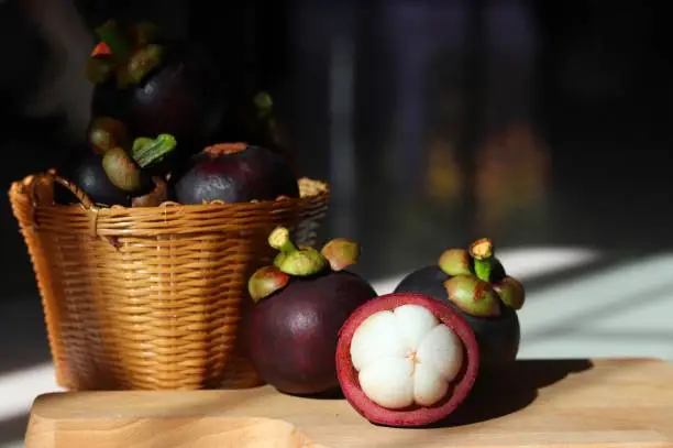 Photo of mangosteens in the basket on white background. isolated natural fruit.