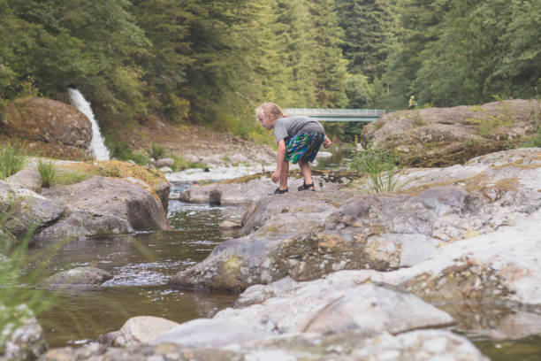 istock Boy preparing to leap into the river from a boulder 1129059930