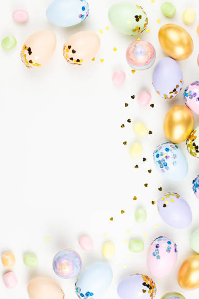 istock Festive Happy Easter background with decorated eggs, flowers, candy and ribbons in pastel colors on white. Copy space 1129062890