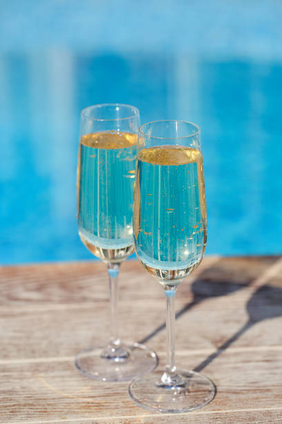 istock Champagne glasses near swimming pool. 1129063523