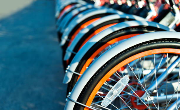 fila de bicicletas en la acera de estacionamiento - bikeshare fotografías e imágenes de stock