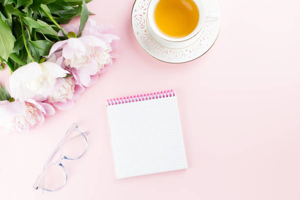 istock Beautiful cosmetics and flowers flat lay with note book, herbal tea on pastel background. 1129069166