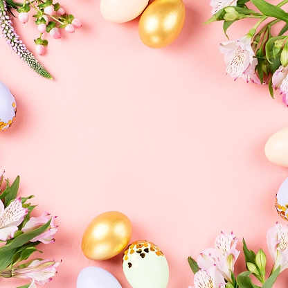 Festive Easter background with decorated eggs, flowers, candy and ribbons in pastel colors on pink background