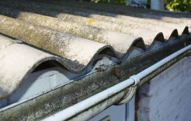 istock Old asbestos roof with dirty roof gutter. 1129069265