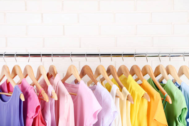 istock Fashion clothes hanging on brick wall background 1129069596