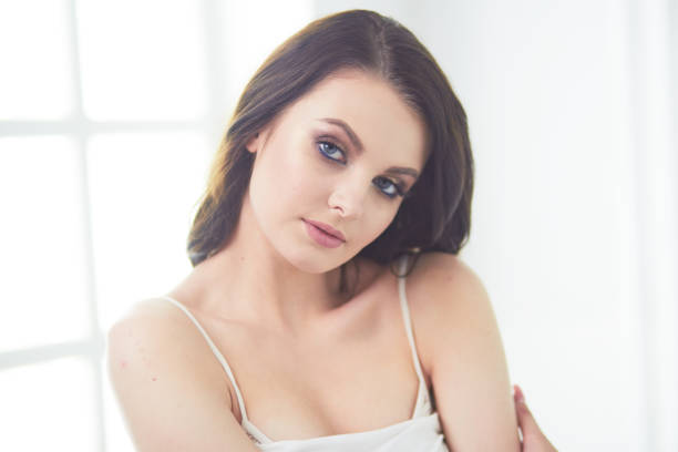 istock Beautiful brunette lying on bed at home 1129069600