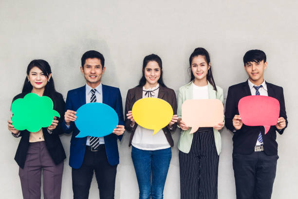 istock Group of business people holding a speech bubble icon 1129070609