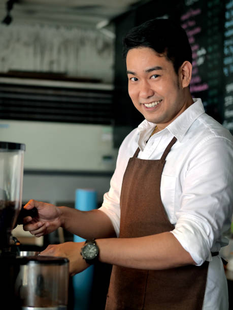 istock Happy Asian barista man working in cafe. 1129072367