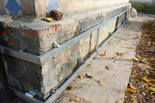 istock House foundation wall repair,  renovation  with installing metal sheets on metal frame for waterproofing and protect from wetness. 1129073283