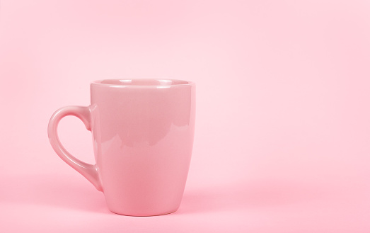 Pink mug on pink background. Pink cup. Copy space