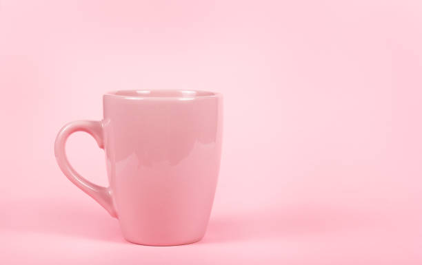 Pink mug on pink background. Pink cup. Copy space stock photo