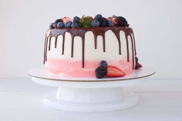 istock Cake with chocolate, decorated with various berries on a white table. 1129074914