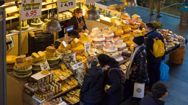 Rotterdam, the Netherlands - February 1, 2019: Customers at a cheese stall in the Markthal. The Market Hall (Markthal) consists of apartments and variety of market stalls and cafes in the large atrium inside.