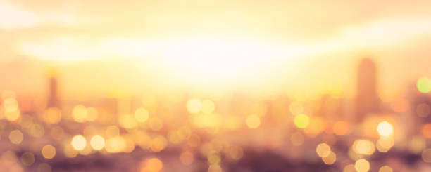 sol de verano desenfoque atardecer de cielo hora dorada con la ciudad en la azotea vista fondo paisaje urbano edificio de oficinas paisaje borrosa luces urbano horizonte bokeh para fiesta de noche - warm lighting fotografías e imágenes de stock