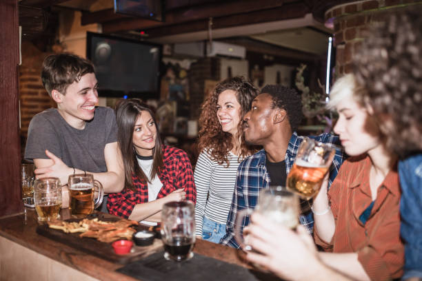 istock Group of friends spending time together, drinking beer in the pub 1129077790