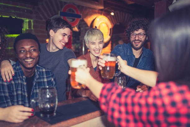 istock Group of friends spending time together, drinking beer in the pub 1129077826