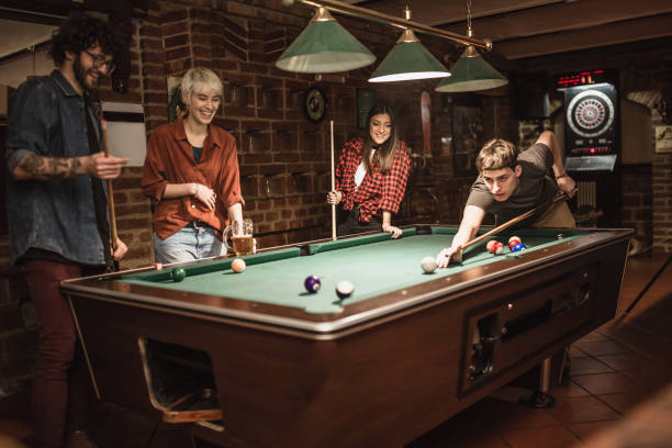 grupo de amigos jugando billar y divirtiéndose juntos en un bar. - snooker fotografías e imágenes de stock