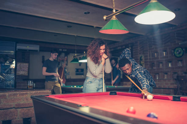 istock Young African man teaching his girlfriend to play pool 1129077861